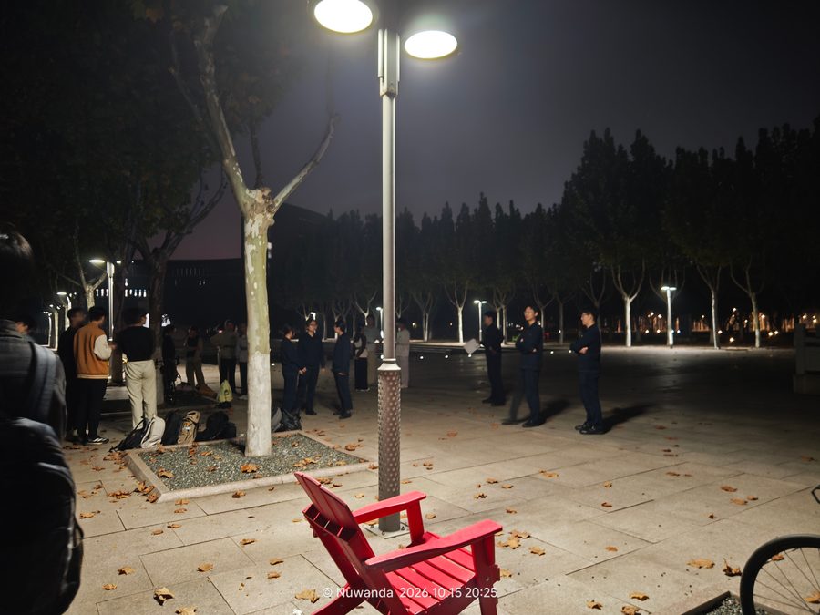 夜晚路灯下的广场，国旗护卫队队员在灯下集合训练